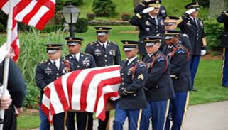 A group of military men standing around an american flag draped coffin.